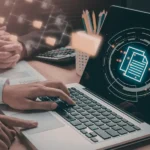 Dłonie nad laptopem z hologramem dokumentów, dane testowe a GDPR i pseudonimizacja