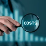 Lupa z napisem costs nad wykresami, jakość oprogramowania jako niewidzialny koszt firmy