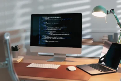 Biurko z monitorem i kodem, testy manualne kontra automatyzacja testów w małej firmie