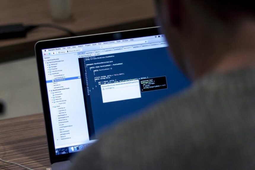Ekran laptopa z kodem podczas pracy zespołu testerskiego nad jakością oprogramowania
